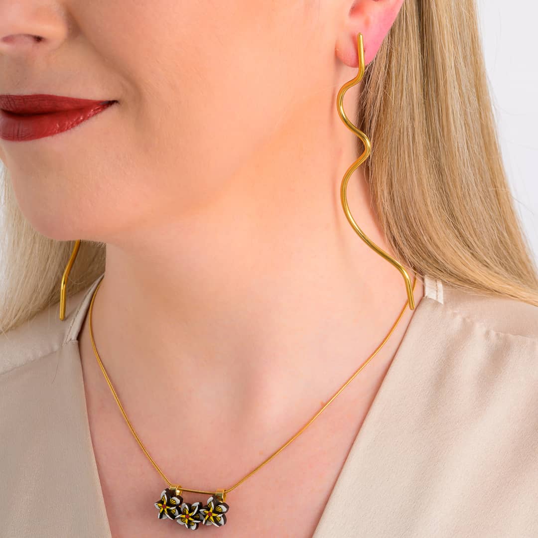 Model wearing Wimbi recycled brass statement earrings