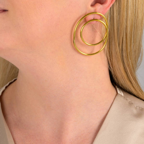 Dira recycled brass statement earrings worn by a model
